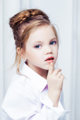 Cute little blond girl wearing white casual clothes on a white background. Fashion style.