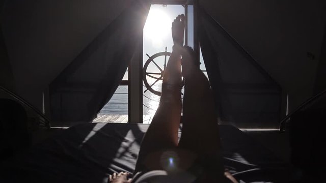 A young girl woke up early in the morning in bed with a view of the sea and a terrace