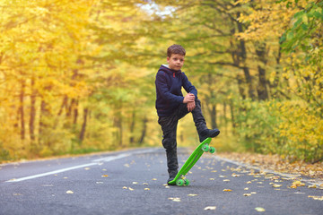 Kid skateboarder doing skateboard tricks in autumn environment