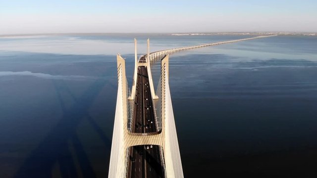 Traffic on Vasco da Gama bridge over the Tagus at sunset in Lisbon, Portugal, aerial view.