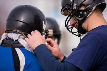 American football players checking helmets
