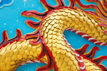 Detail of golden dragon scale low relief sculpture in Chinese temple wall, Kanchanaburi Thailand