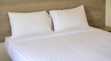 Close-up white pillows on bed in hotel.