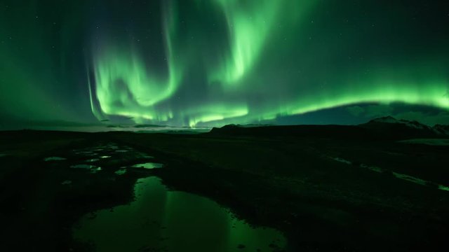 Bright realistic Aurora Borealis over mountains, reflecting in puddles, Skaftafell Iceland.mov