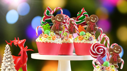 On-trend candyland festive Christmas cupcakes against bokeh lights background.
