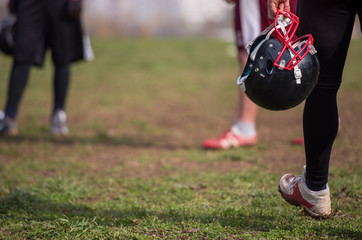American football player holding helmet