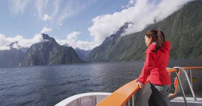 Tourist on boat tour in Milford Sound, Fiordland National Park, New Zealand. Happy couple on sightseeing travel on New Zealand South Island. RED EPIC SLOW MOTION.