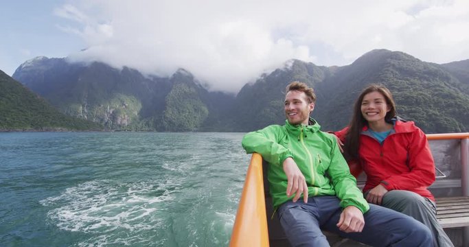 Cruise ship tourists on boat tour in Milford Sound, Fiordland National Park, New Zealand. Happy romantic couple on sightseeing travel honeymoon on New Zealand South Island. RED EPIC SLOW MOTION.