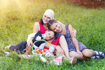 mother with two kids having picnic outdoors