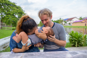 Multi-ethnic young family bonding together at the park