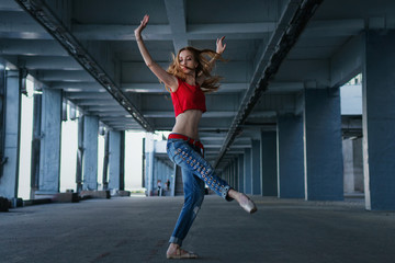 Obraz premium Ballerina dancing in jeans, t-shirt and pointe. Street performance. Modern art. Slender girl dancing on tiptoe.
