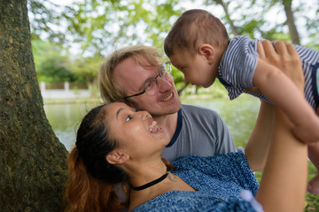 Fototapeta premium Multi-ethnic young family bonding together at the park
