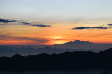 Early sunrise view from Gunung Batur volcano in Bali, Indonesia with visible silhouette of Rinjani mountains