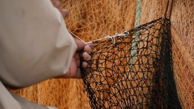 A fisherman mending his fishing net in Turkey.