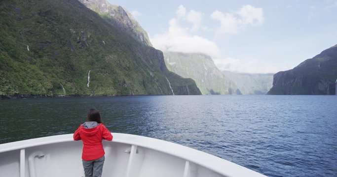 Cruise ship tourist on travel in New Zealand Milford Sound Fiordland National Park. Tourist enjoying boat tour and amazing view of fjord in most famous travel destination in New Zealand.