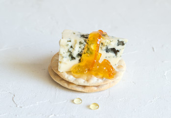 Roquefort cheese on cracker topped with orange marmalade