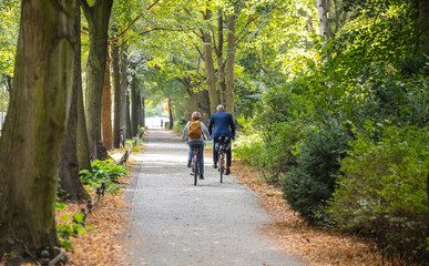Tiergarten city park in Berlin, Germany. View of a mature couple riding bicycles