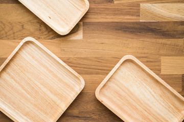 Top view of unused brand new brown handmade wooden kitchen utensil, dish plate on wooden table background