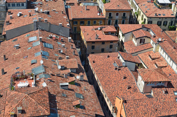 Fototapeta na wymiar On the red tiled roofs of a small no name Italian city there are many satellite TV antennas