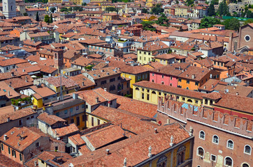 Fototapeta na wymiar On the red tiled roofs of a small no name Italian city there are many satellite TV antennas and roof windows