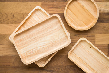 Top view of unused brand new brown handmade wooden kitchen utensil, dish plate on wooden table background