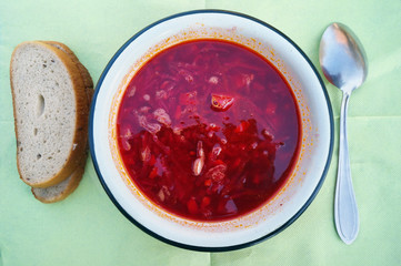 Hot red fat  rustic soup in meat broth from vegetables and beetroot- borsch and bread.