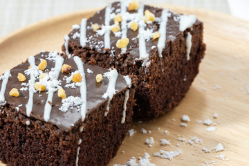 Two chocolate brownies On a plate of wood. Closeup view.