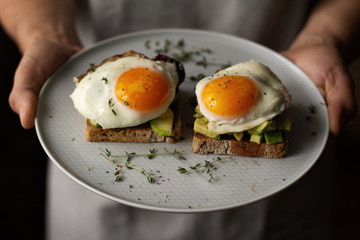 toast with avocado and egg on a plate, breakfast concept.