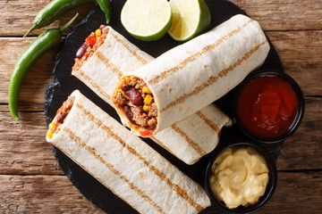 Delicious grilled burrito stuffed with minced beef, beans, corn, pepper and tomatoes and with...