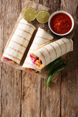 Delicious grilled mexican vegan burrito with rice, beans, corn, tomatoes, peppers and cabbage...