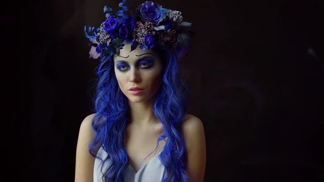 Portrait of beautiful girl with Halloween makeup ready to have Halloween party. Attractive woman looking at camera isolated on black background.