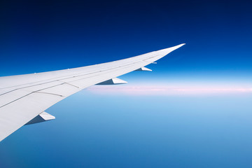 the wing of the aircraft against the blue sky