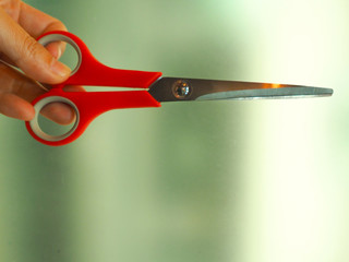  Red scissors on blurred background, close up