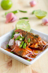 Spicy salad of canned sardines fish on wooden table