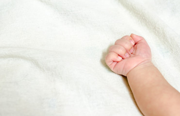 Newborn baby hand on white bed