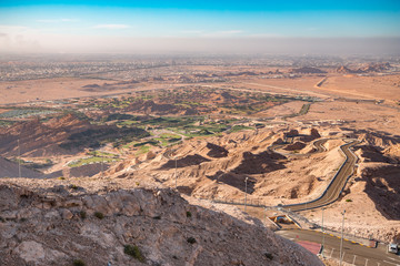 Scenic winding road in Al Ain, UAE: Jebel Hafeet mountain panoramic view towards Green Mubazzarah resort 