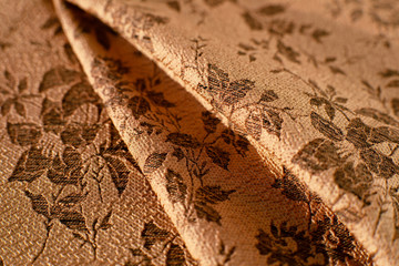 Texture of jacquard fabric. Brown pleated jacquard fabric creates a textural background. Fabric for sewing clothing and decorative items.