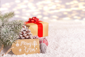 Gifts in the snow with fir branches against a blurred background