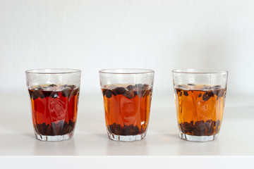cascara tea in glass on white table background, eco-friendly unique drink