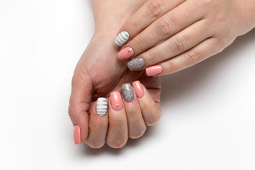 Pink, beige white manicure with silver stripes, crystals, silver glitters on short square nails on a white background close-up
