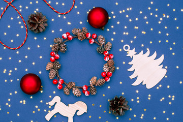 Christmas new year layout of wooden objects, sequins, decorative ornaments and a wreath of cones