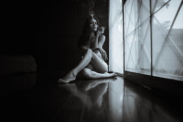portrait noir et blanc femme fumant dans la chambre avec balcon