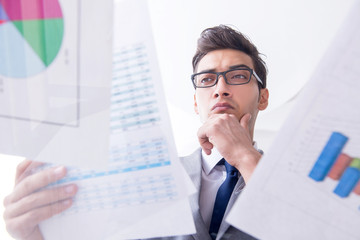 Businessman looking at financial charts and graphs