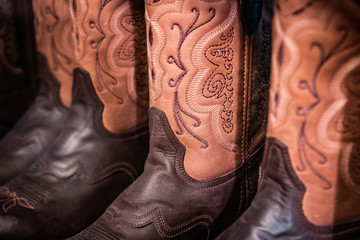 Traditional American handmade leather Cowboy boots, Western show, rodeo market and riding gear on display. National folklore, outdoor and adventure  lifestyle concept.