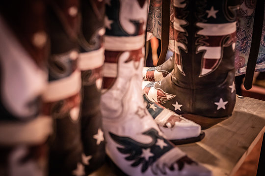 Traditional American handmade leather Cowboy boots, Western show, rodeo market and riding gear on display. National folklore, outdoor and adventure  lifestyle concept.