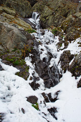 Fototapeta na wymiar Waterfall in snow on Transfagarasan highway, Romania