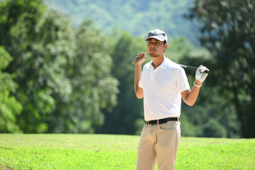 Portrait of handsome young Asian man golfer with golf club