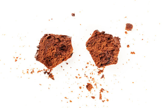 An overhead photo of messy chocolate muffins with crumbs, shot from the top on a white background with copy space