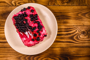 Ceramic plate with cheesecake on wooden table. Top view