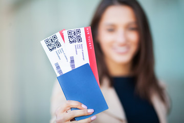 Business woman holding air tickets. Traveller walking the airport hall